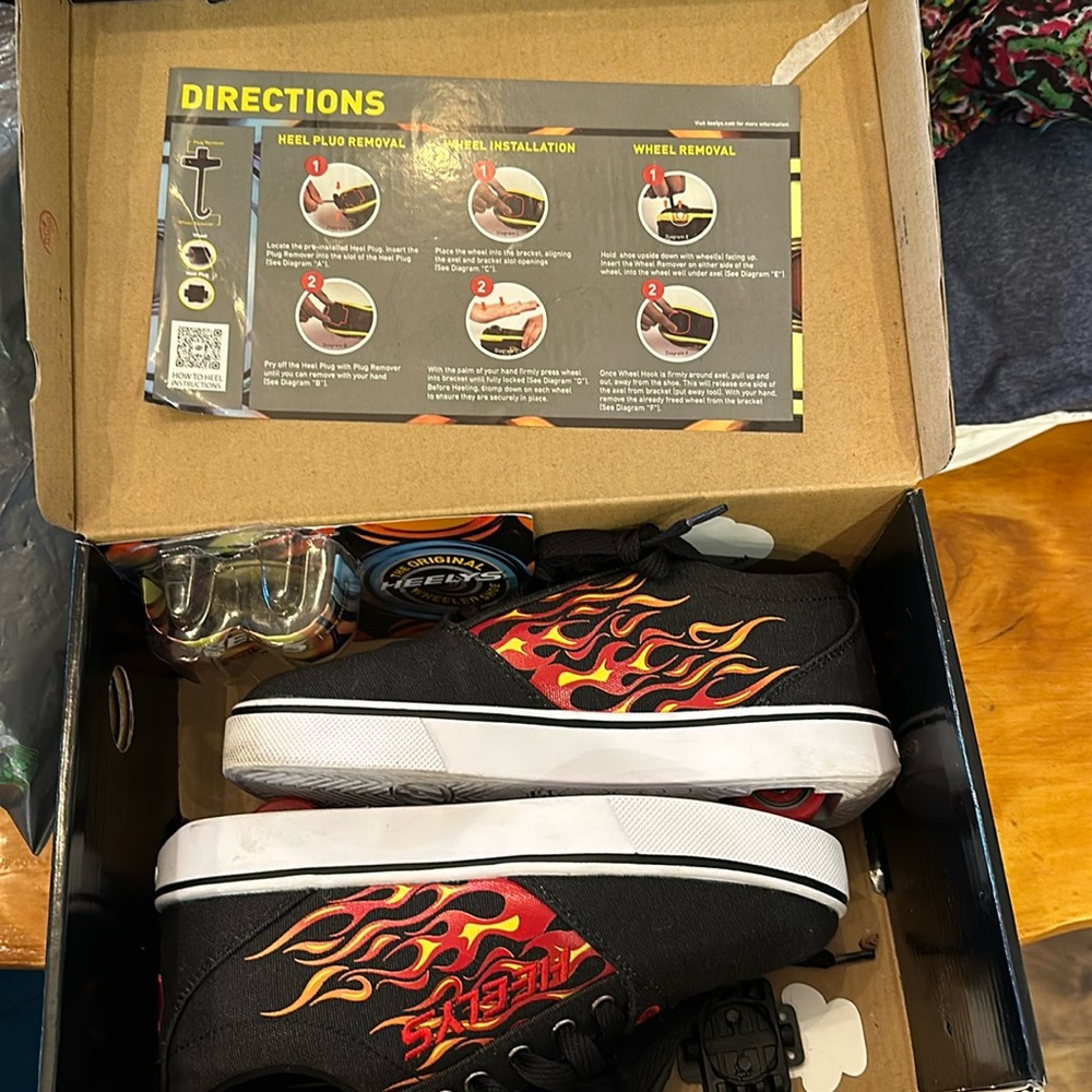 Boys Flame Heelys. Barely used. Still in box. Missing plug removal tool.